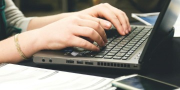 Hände liegen auf einer Laptop-Tastatur